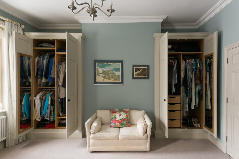 Guest bedroom wardrobes shaped around fireplace