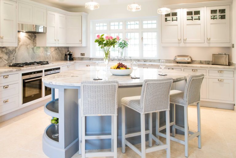 Kitchen island with white marble worktop and cream bar stools
