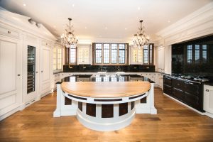 Curved kitchen island with dark and cream two-tone cabinetry