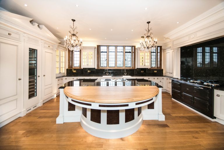 Curved kitchen island with dark and cream two-tone cabinetry