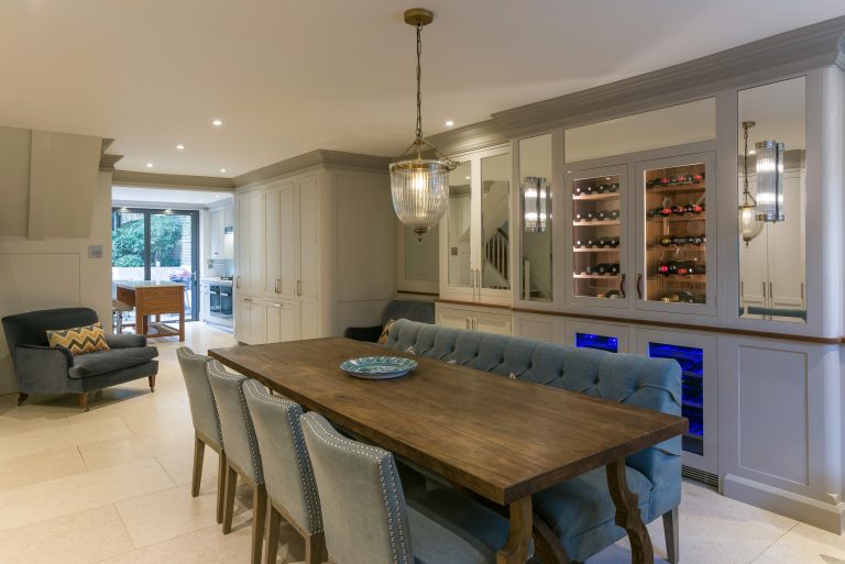 Open-plan kitchen and dining area with pendant lighting and blue banquette seating
