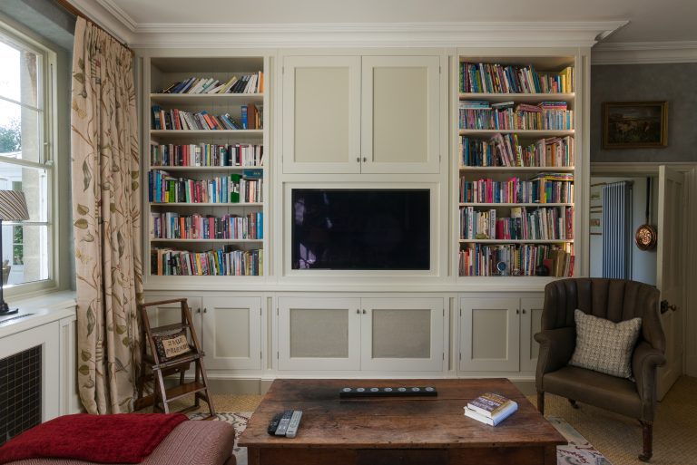 Built-in bookshelves and cabinetry with an integrated wall-mounted TV, different angle