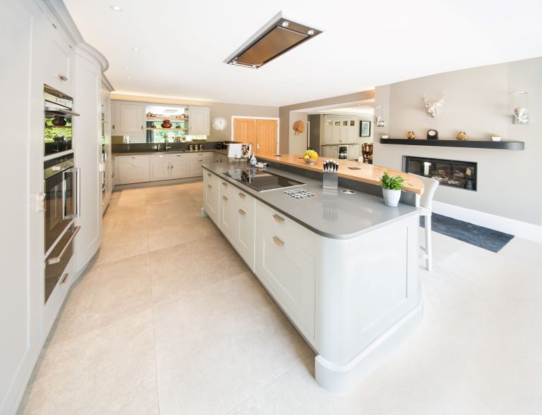 Kitchen with pale cabinetry, oak accents