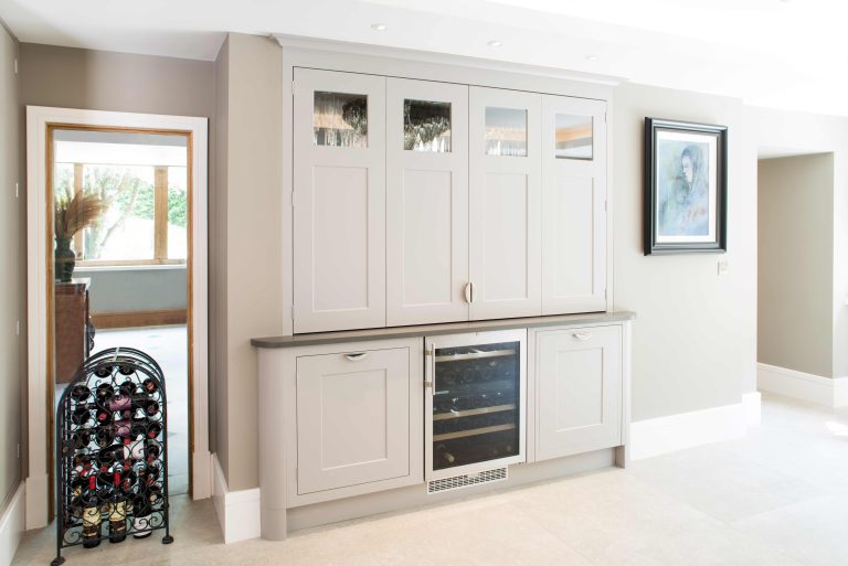 Glazed display cabinetry with dark window frames in the background