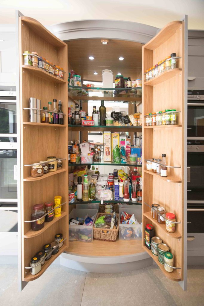 Fitted pantry shelving stocked with jars and packaged goods