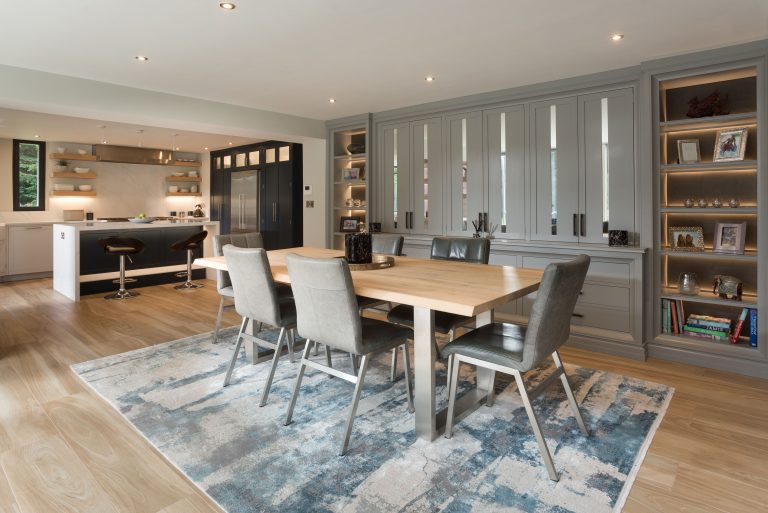Kitchen with pale grey cabinetry and a dining table with upholstered chairs