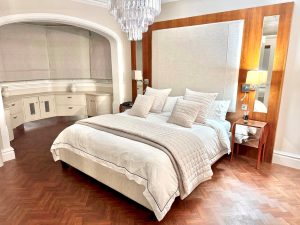 Bed with a tall cream upholstered headboard